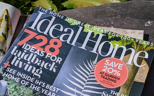 August 2023 issue of Ideal Home magazine laying on garden bench in the sunshine