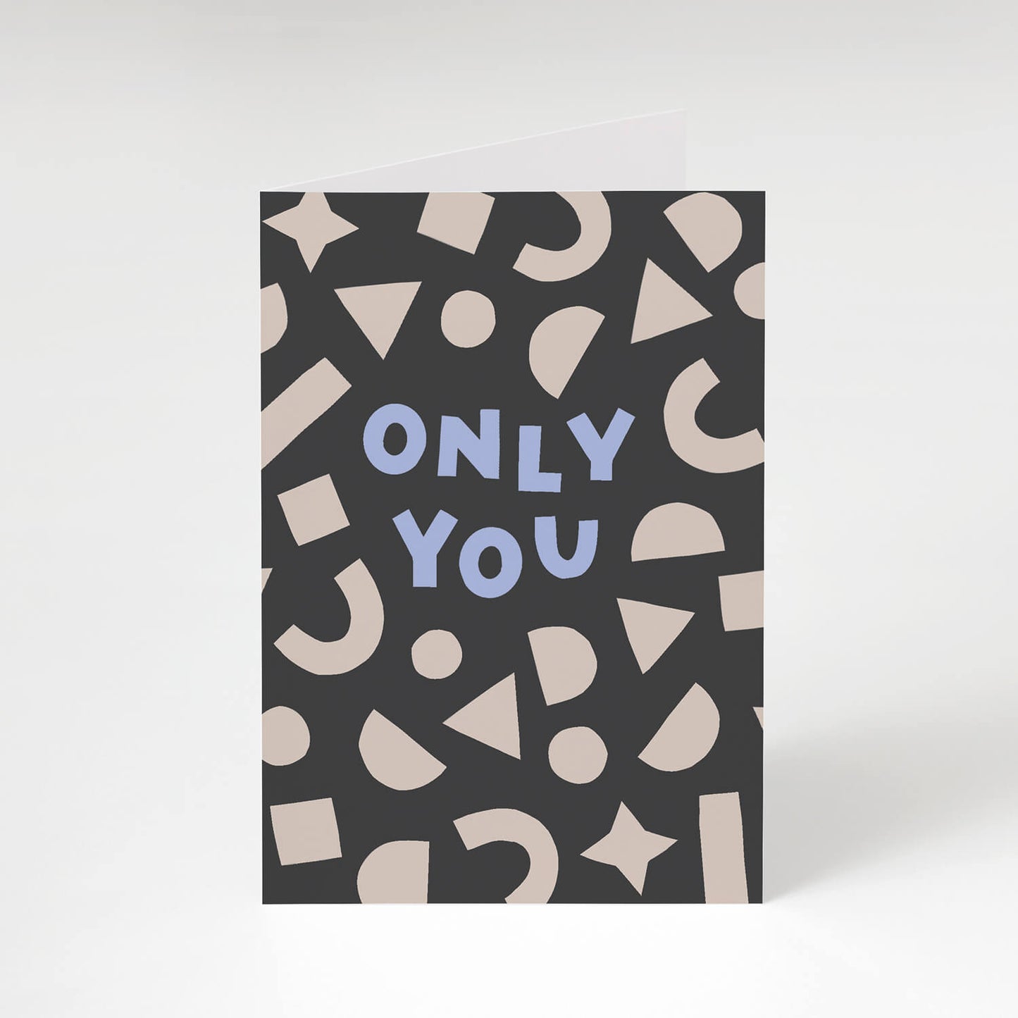 Modern love card featuring playful cream shapes framing the hand lettered words 'Only You' on a dark grey background.