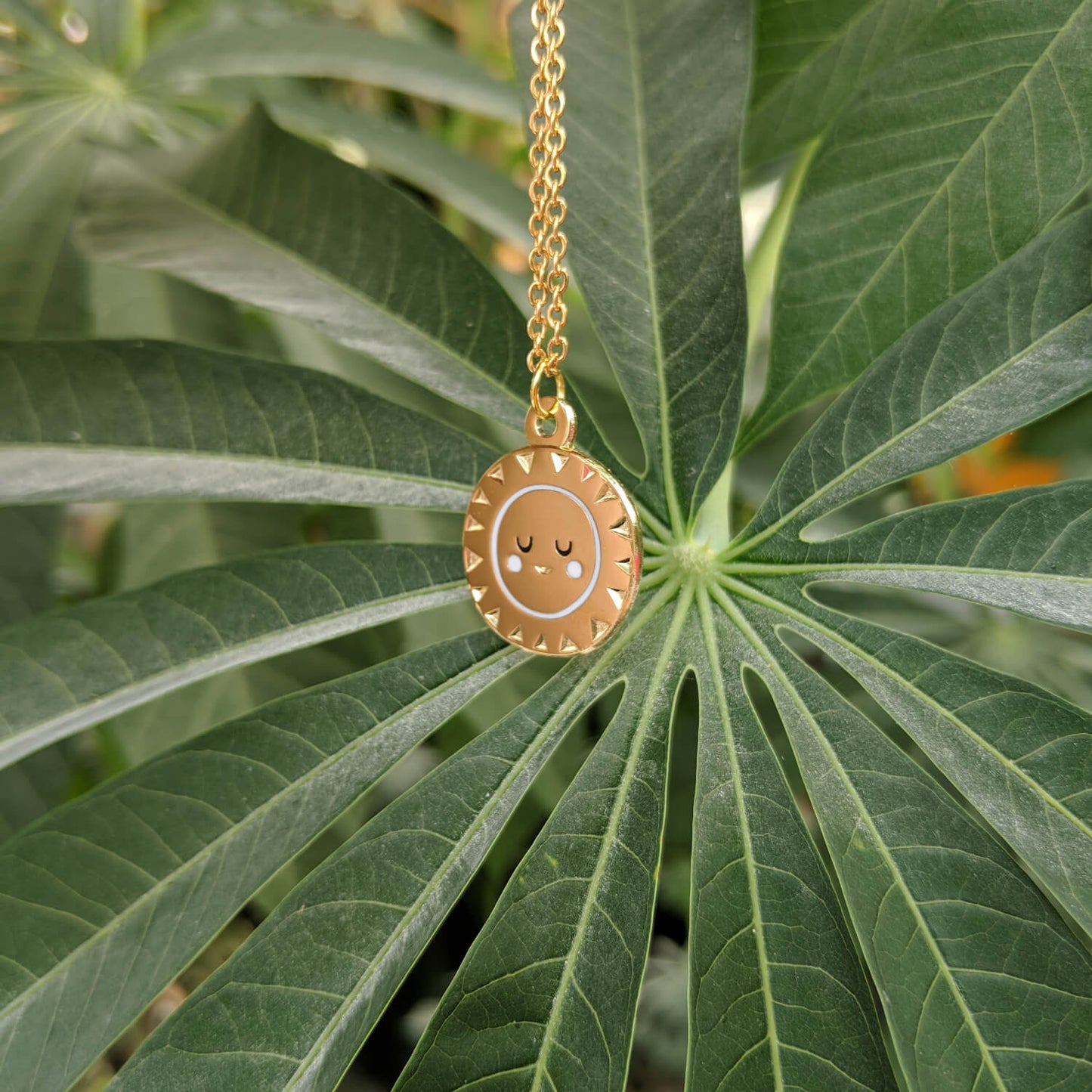 Gold sun pendant on gold chain